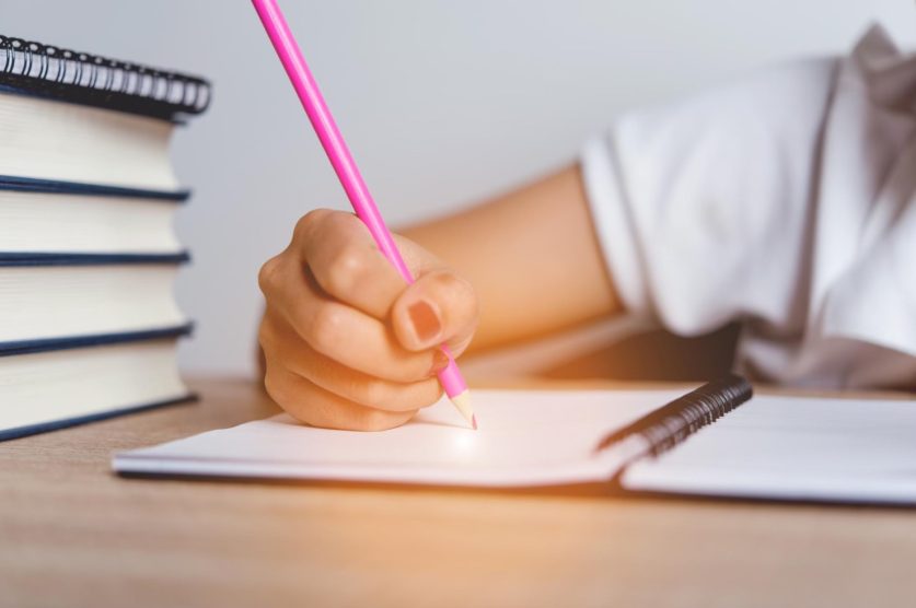 Cat dureaza examenul Cambridge copil care studiaza creion roz caiet